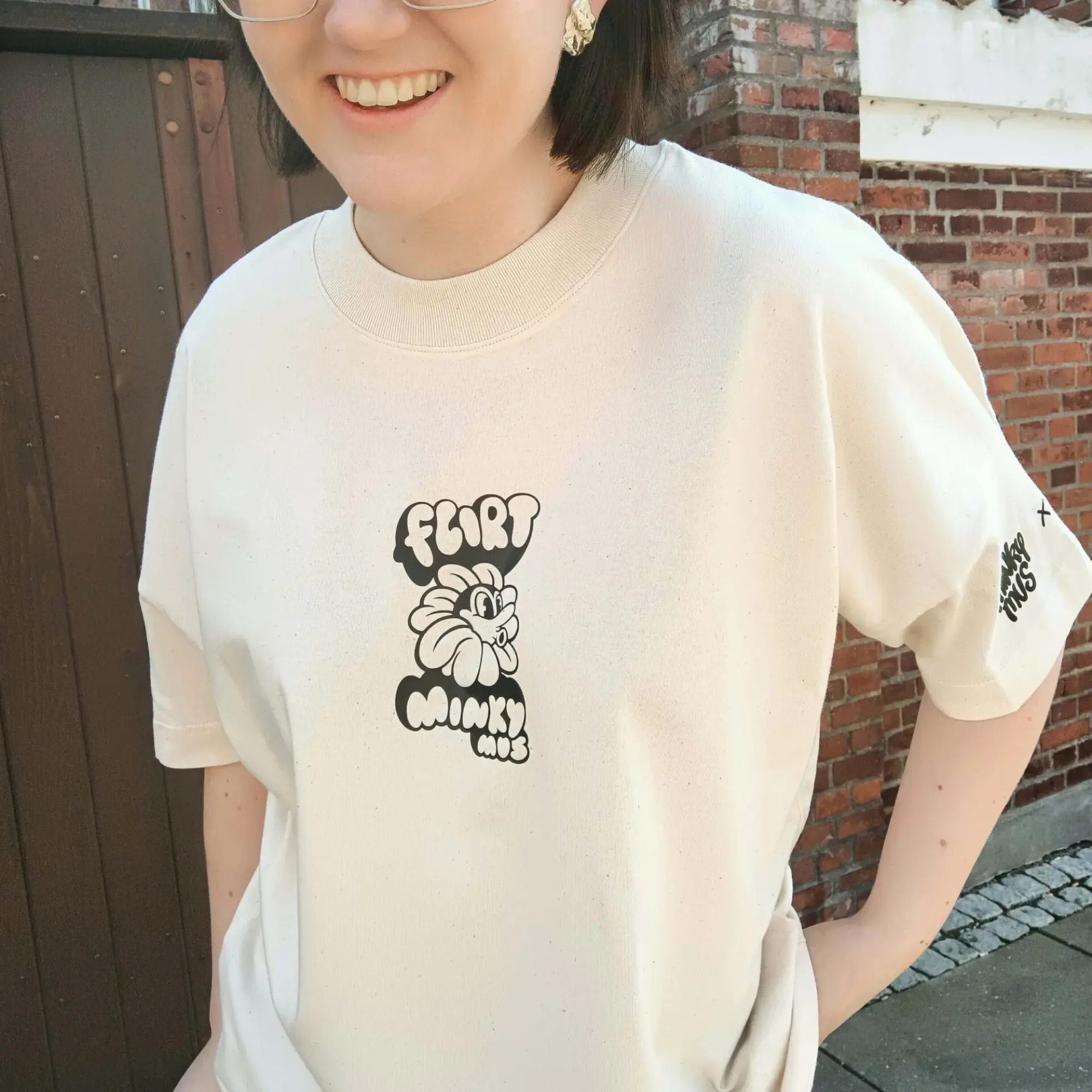Unisex Minky Mus x FLIRT t-shirt lavet af økologisk bomuld, er PETA vegan approved og GOTS certificeret. Findes i beige, som en minimalistisk dansk oversized streetwear t-shirt til kvinder og mænd.